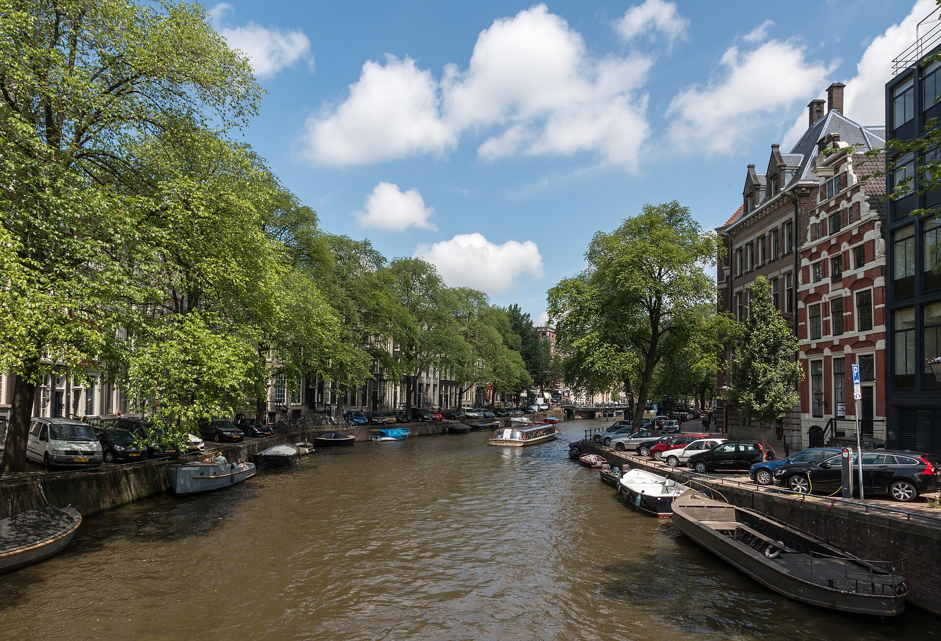 Boats moored along the Herengracht canal in Amsterdam on a sunny day